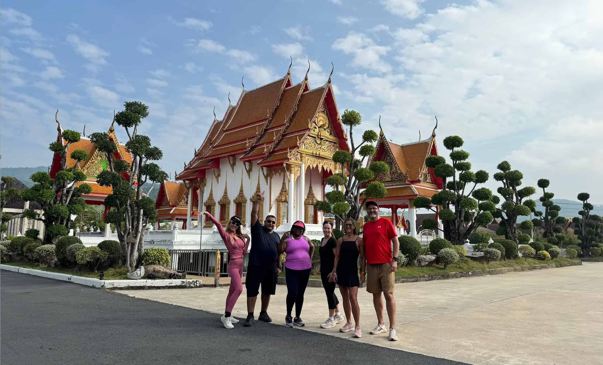 Screenshot A group of wellness retreat clients visiting a serene temple in Phuket, experiencing Thai culture and mindfulness.